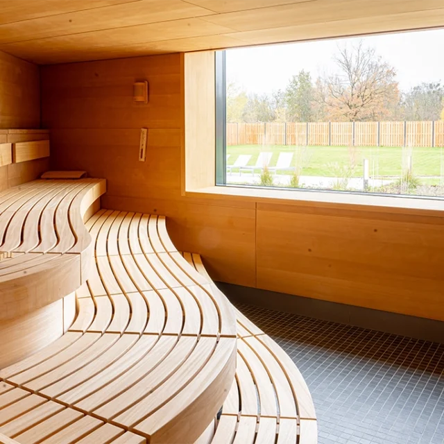 Bio-Aroma Sauna mit Holzbänken und Fenster mit Blick in den Saunaaussenbereich
